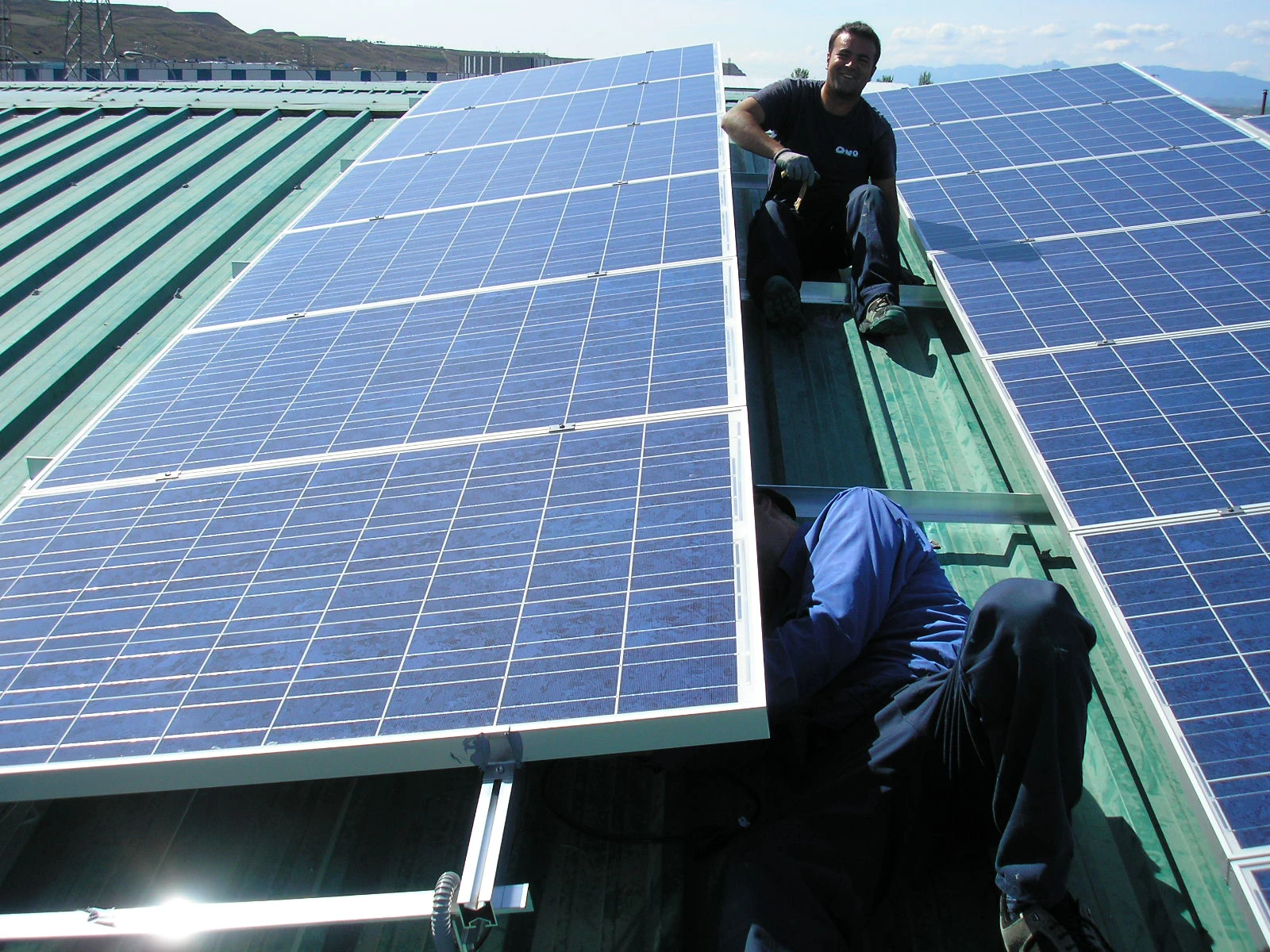 Persona sonriente instalando placas solares en un tejado